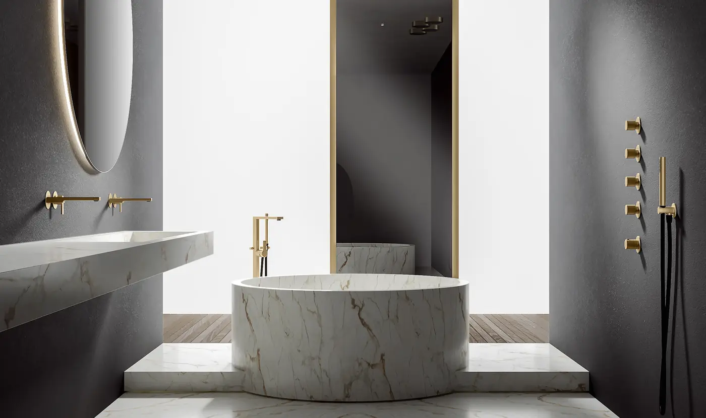 Bagno con vasca in marmo e rubinetteria in finitura oro