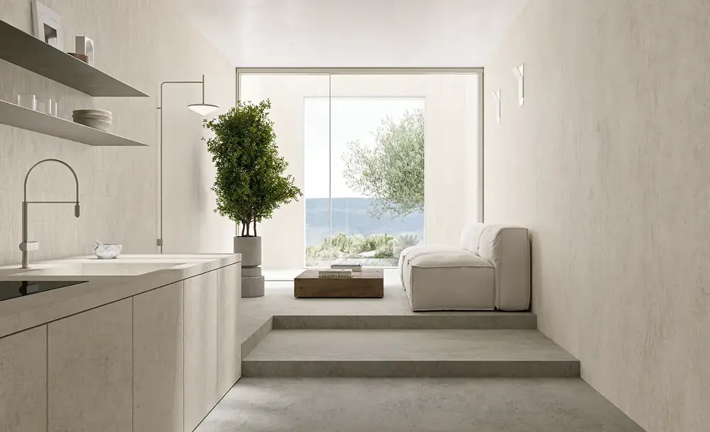 Cucina con rivestimento materico chiaro a pavimento e parete