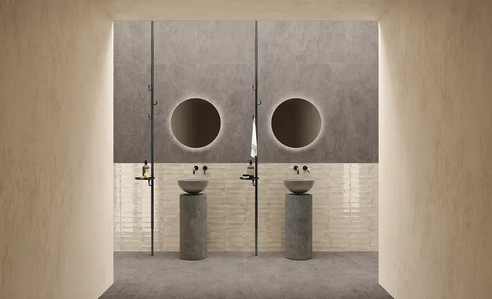 Bagno con pareti effetto pietra e lavabi su colonna