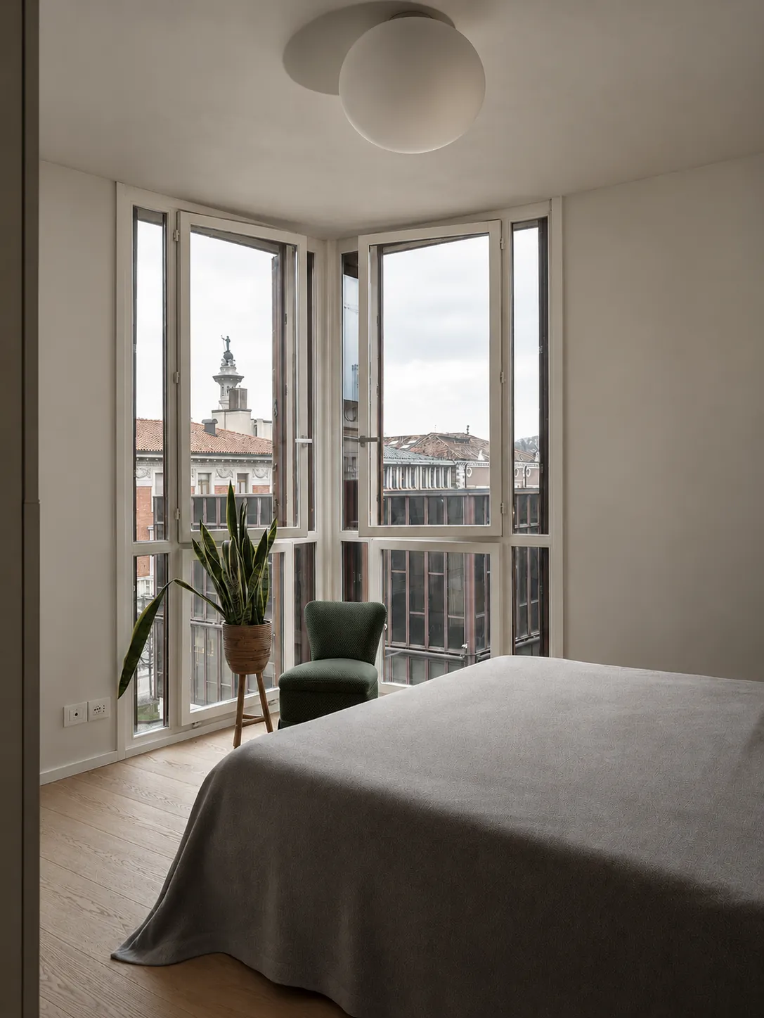 Camera da letto con finestre angolari sui tetti di Pordenone